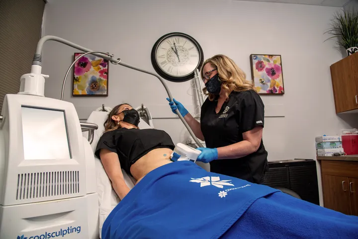 CoolSculpting treatment being performed on a woman’s abdomen at a med spa.