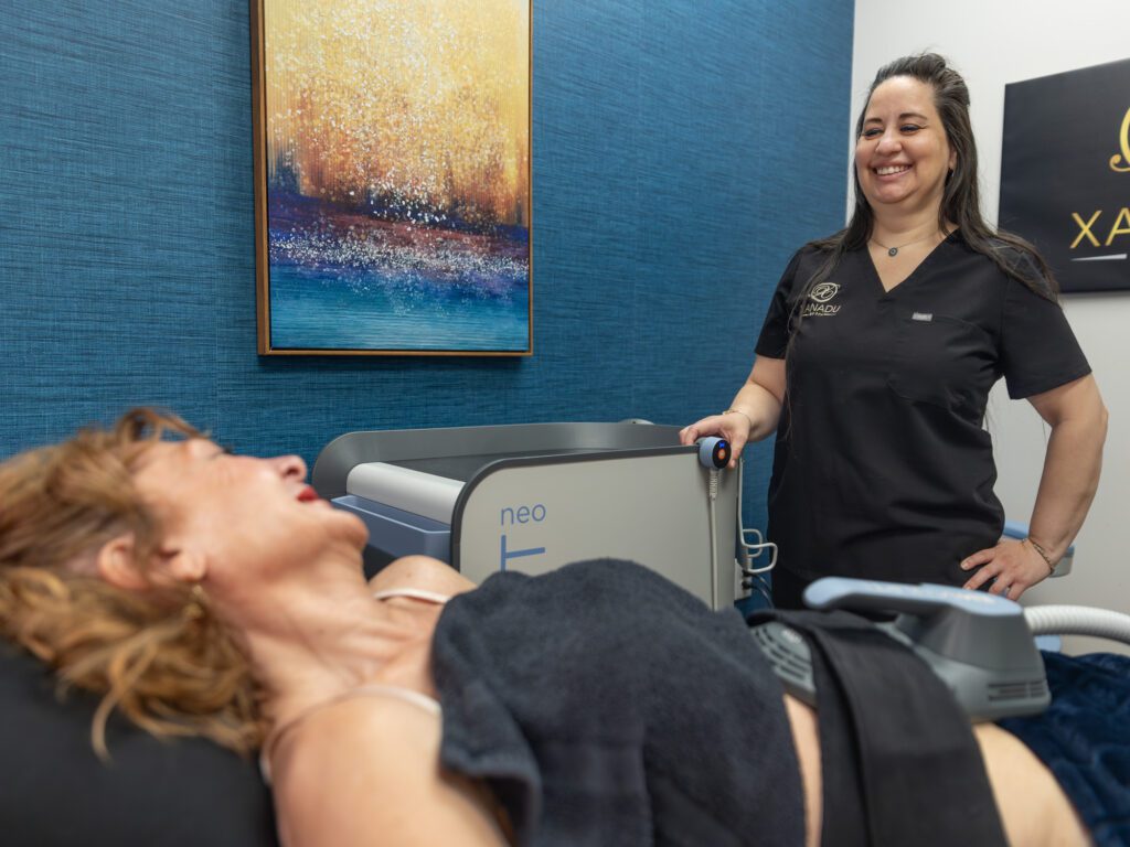Patient receiving body contouring treatment with smiling technician