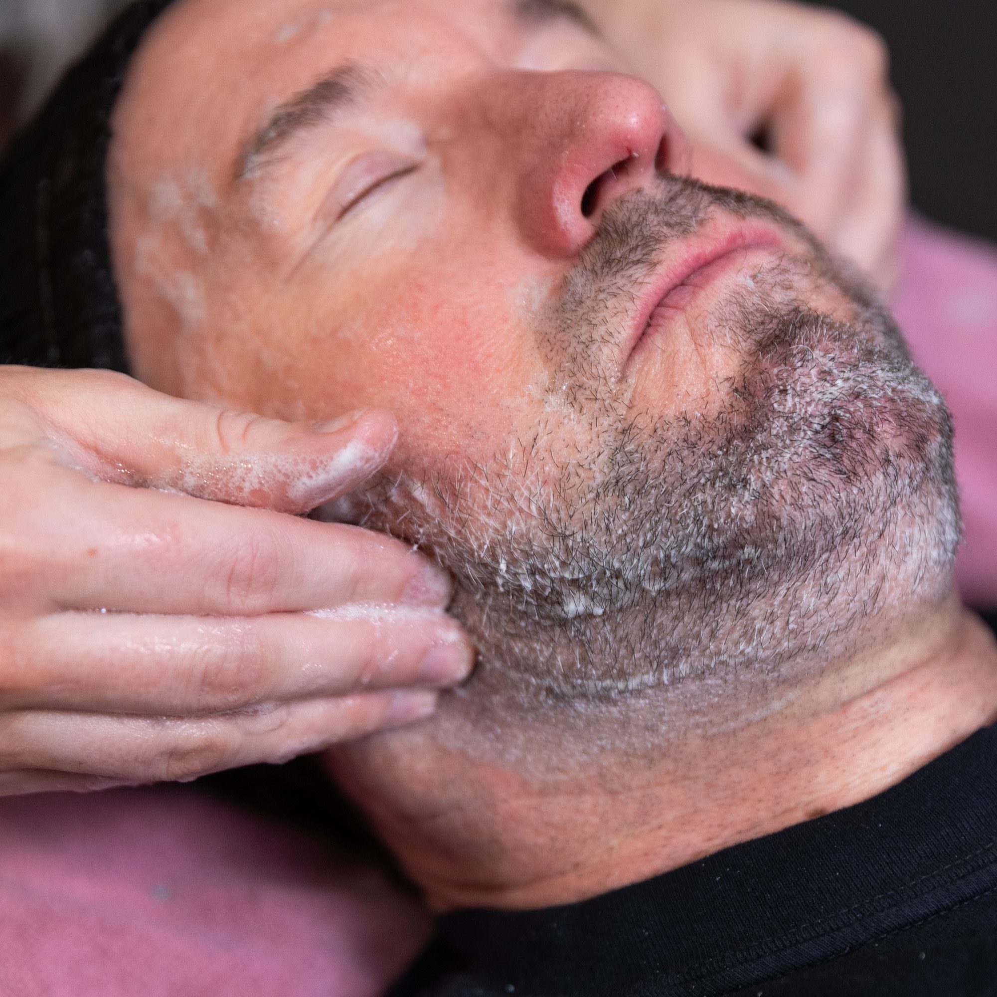 man receiving relaxing facial treatment