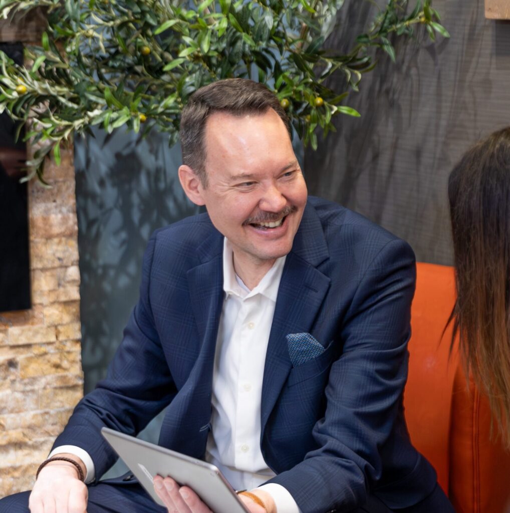Man smiling while holding digital tablet
