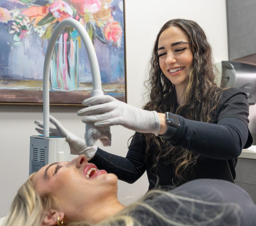 Aesthetician performing facial treatment on patient