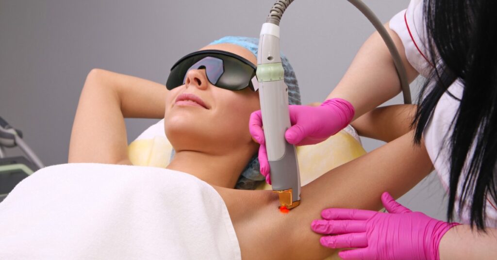 A woman is undergoing laser hair removal on her underarm
