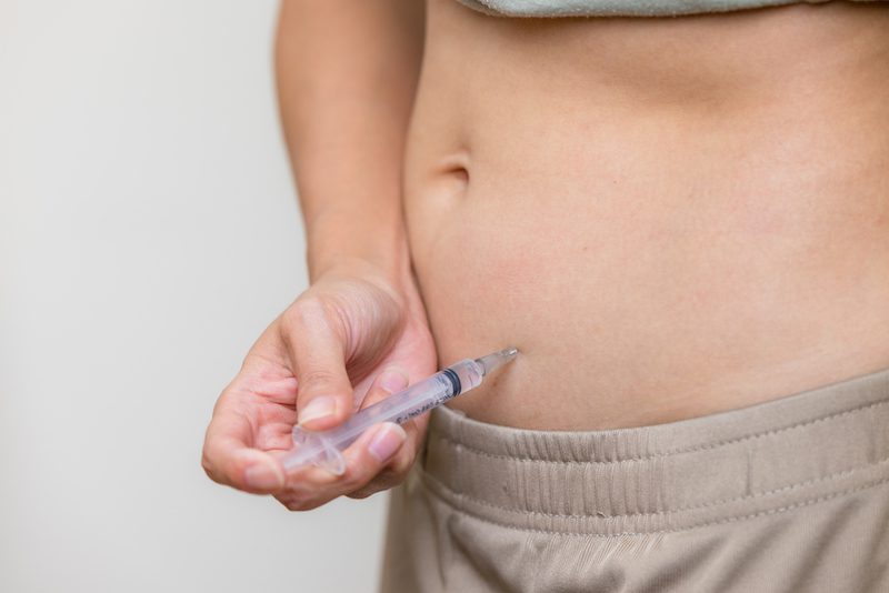 A woman is injecting semaglutide into her abdomen after receiving her prescription from Xanadu's weight loss clinic in Fort Collins.