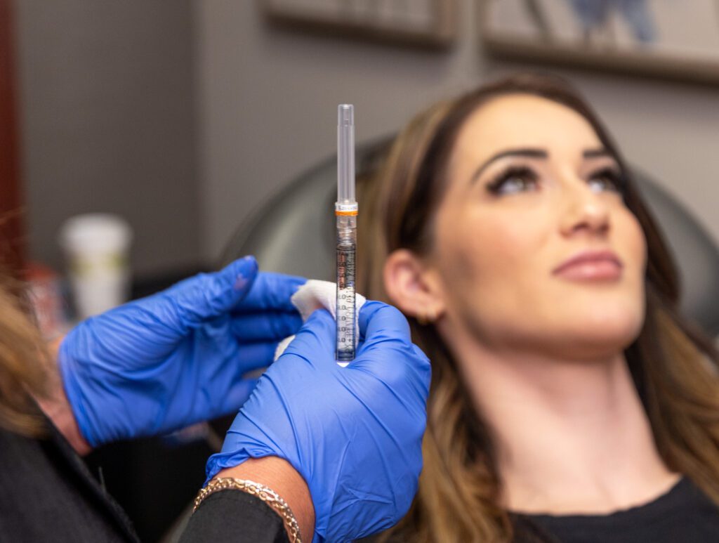 A Xanadu provider is holding up a syringe for lip filler in Fort Collins.